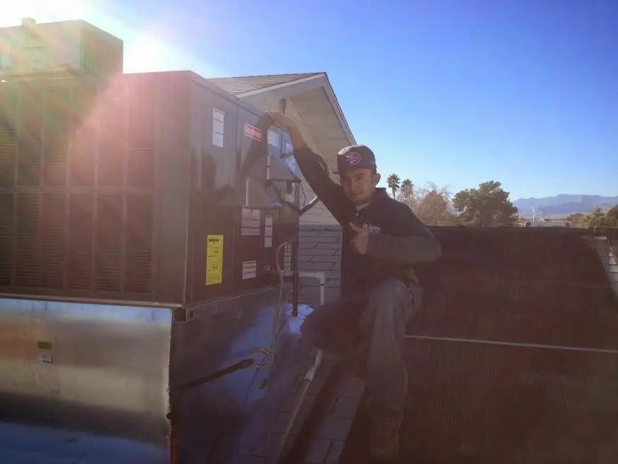 HVAC technician performing HVAC Inspection on a rooftop unit in Chantilly
